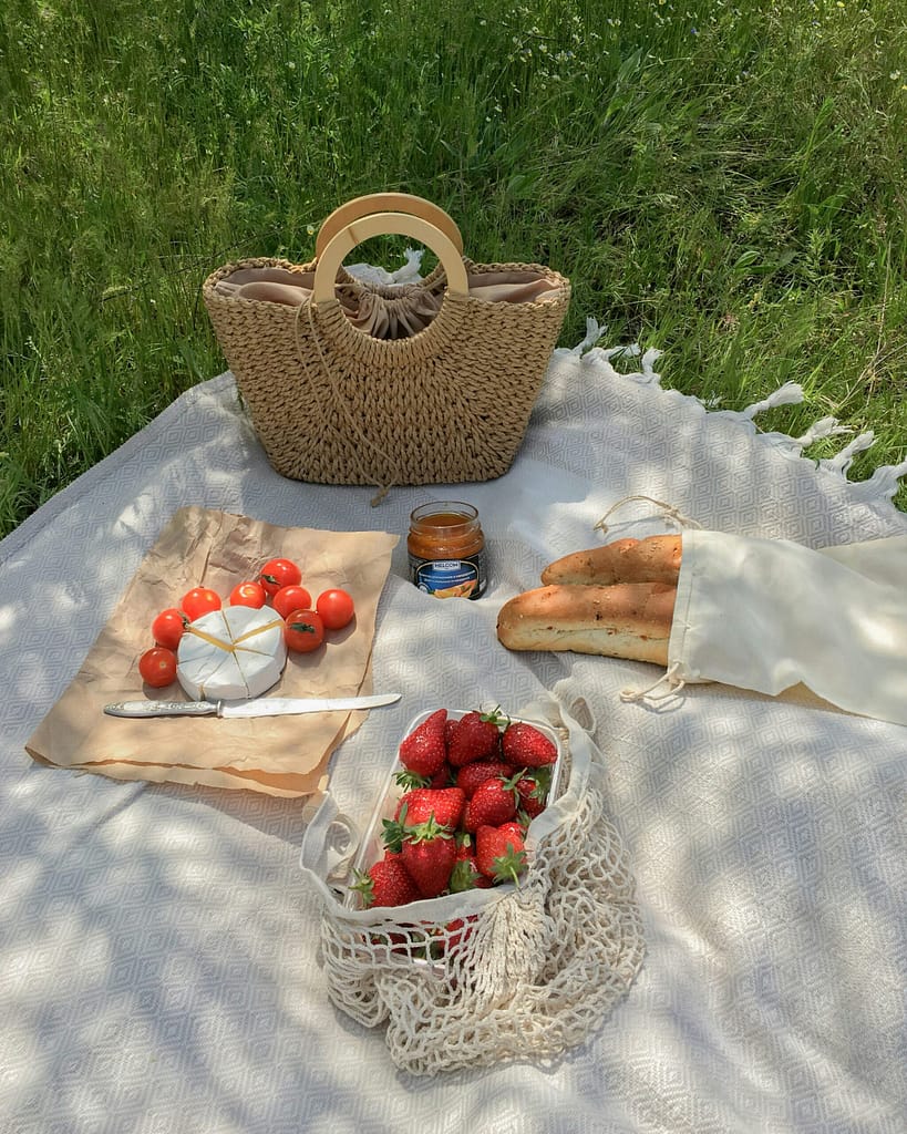 Eco-Friendly Summer: 10 Sustainable Swaps for the Hot Season Reusable water bottle, straw, sunglasses, and eco-friendly summer essentials on a picnic table in the sun